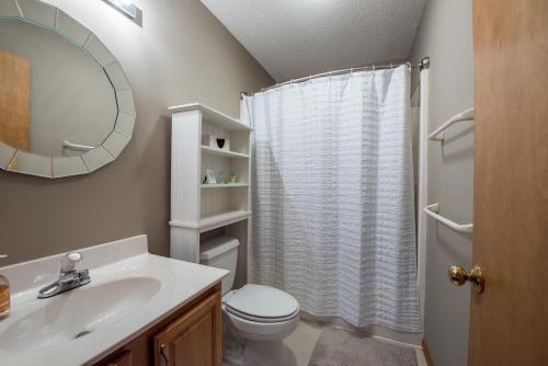 a bathroom with a toilet and a sink and a mirror at Sunset Peaks by Carolina Mornings in Asheville
