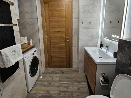 a bathroom with a sink and a washing machine at Happy Dreams Spa Zlatibor in Zlatibor