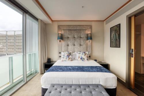 a bedroom with a large bed and a large window at Marsden Viaduct in Auckland