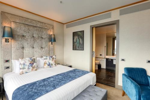 a hotel room with a bed and a blue chair at Marsden Viaduct in Auckland