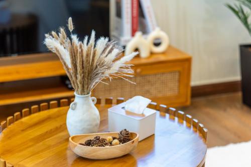 a table with a vase and a bowl of dried flowers at La Ferringhi Villa - Tropical Collection, by ALV in Batu Ferringhi