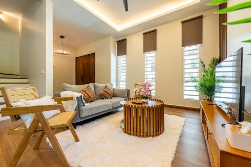a living room with a couch and a table at La Ferringhi Villa - Tropical Collection, by ALV in Batu Ferringhi
