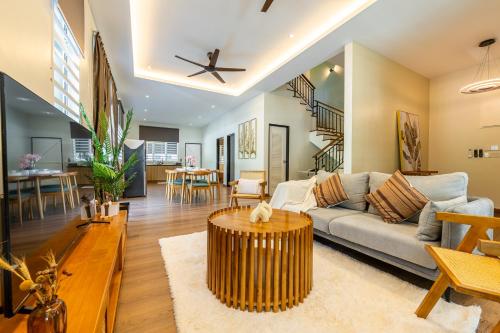 a living room with a couch and a table at La Ferringhi Villa - Tropical Collection, by ALV in Batu Ferringhi