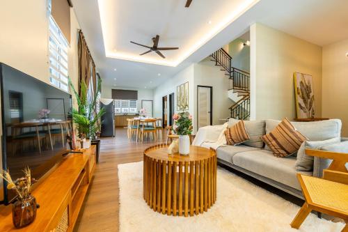 a living room with a couch and a table at La Ferringhi Villa - Tropical Collection, by ALV in Batu Ferringhi