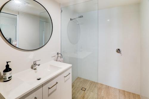 a white bathroom with a sink and a mirror at The Archer Retreat in Villeneuve