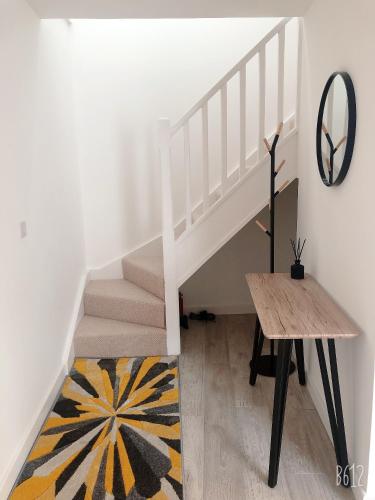 a white staircase with a wooden table and a rug at Cottage House - Preston Village - Preston Park in Brighton & Hove
