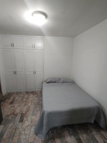 a bedroom with a bed and white cabinets at Santafe Suites in Hermosillo