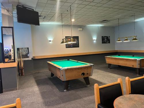 a billiard room with two pool tables in it at The Lodge Inn in Edmonton