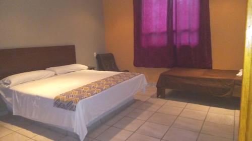 a bedroom with a bed and a table and a window at Villas y Suites 304 in Tampico