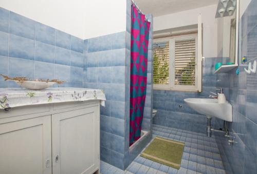 une salle de bain carrelée bleue avec un lavabo et une douche dans l'établissement Apartments by the sea Podgora, Makarska - 23678, à Podgora