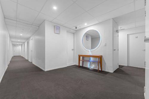 a hallway with a table and a mirror on a wall at Onehunga Suites in Auckland