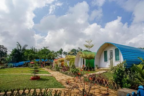 a house with a blue roof and a garden at Rainbow Glamping in Padangan