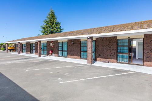 an empty parking lot in front of a brick building at Lavana Motel in Hastings
