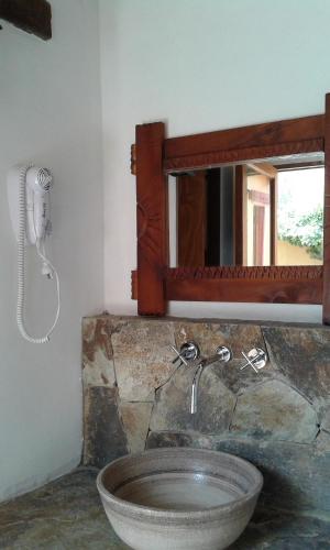 a bathroom with a stone sink and a mirror at Cabañas Tilcara Mia in Tilcara