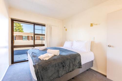 a bedroom with a large bed and a large window at Lavana Motel in Hastings