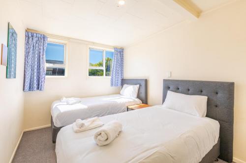 two beds in a room with two windows at Lavana Motel in Hastings
