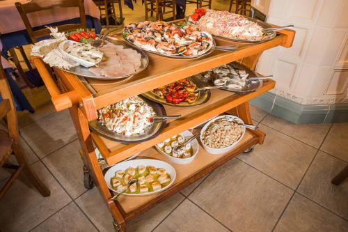 a table with many different plates of food on it at Hotel Bacco in Beinette