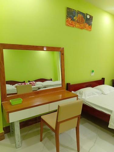 a bedroom with a desk and a mirror and a bed at HOTEL MOTeL ĐỒNG KHỞI in Ben Tre