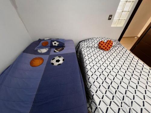 a bed with a soccer ball and balls on it at Casa 2 habitaciones más sofá in Delicias
