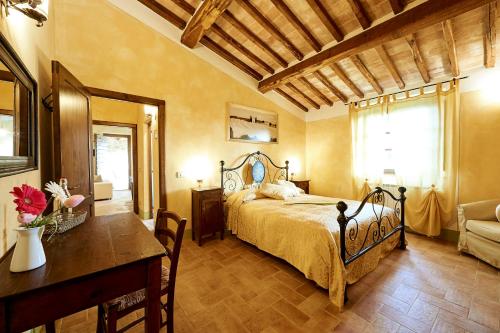 a bedroom with a bed and a table and a table sidx sidx sidx at Agriturismo Il Casalino in Pienza