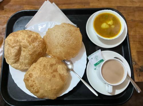 a tray of food with biscuits and a cup of coffee at Hotel Embassy in Dibrugarh