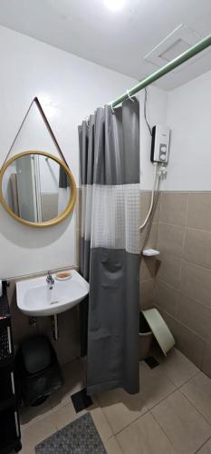 a bathroom with a shower curtain and a sink at Homey822 in Davao City
