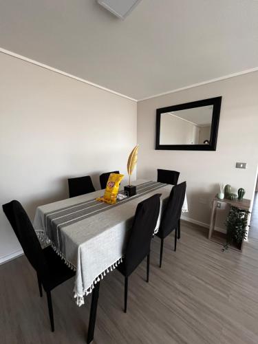 Depto a pasos de la playa 5-6 personas - La Serena في لا سيرينا: غرفة طعام مع طاولة وكراسي ومرآة