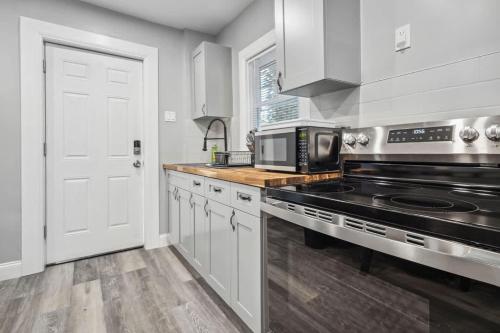 una cocina con estufa y microondas en Quaint 1BR 1BA near the falls, en Niagara Falls
