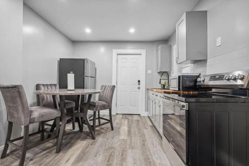 Una cocina con mesa y sillas y un refrigerador. en Quaint 1BR 1BA near the falls, en Niagara Falls