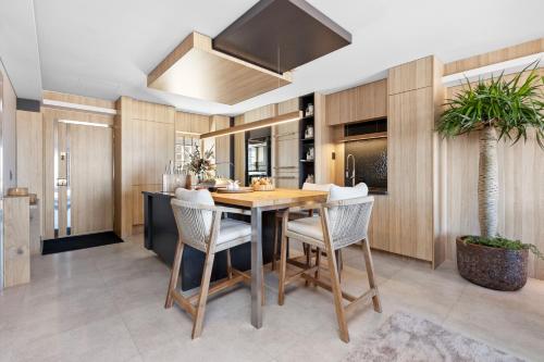 a kitchen with a table and chairs and a palm tree at Nautica Residences Hillarys in Perth