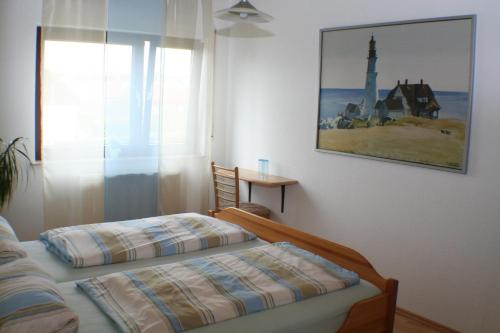 a bedroom with a bed and a picture on the wall at Pension und Weingut Hirschhof in Offenheim