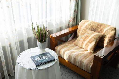 a room with a table with a bed and a vase with a book at Datong Yunzhong Traditional Courtyard in Datong