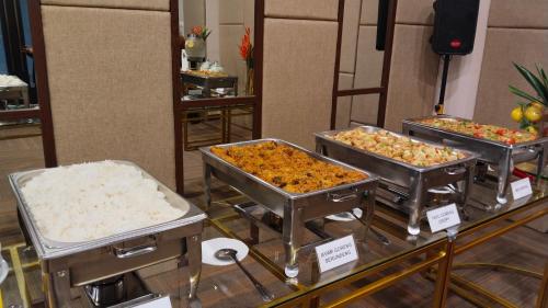 a buffet with three trays of food on display at Cordova Suites in Semarang