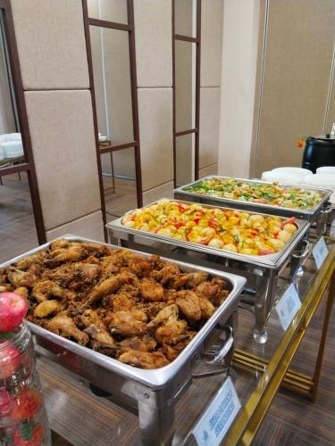 a buffet with several trays of food on display at Cordova Suites in Semarang