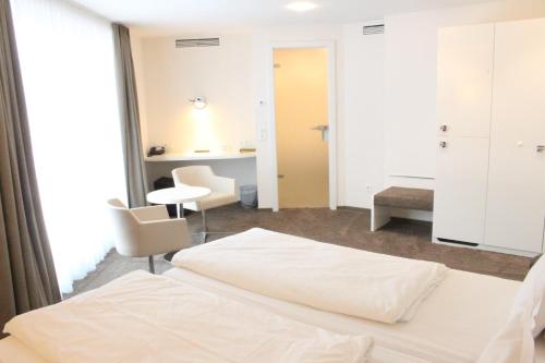 a hotel room with a bed and a desk at Taome Feng Shui Stadthotel Breisgau in Emmendingen