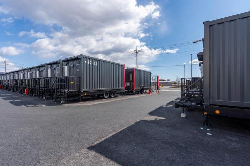 a row of train cars parked in a parking lot at HOTEL R9 The Yard Kiryu in Kiryu