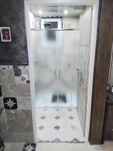 a shower with a glass door in a bathroom at Drissia&Othman Atipik in Carcassonne
