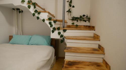 a bedroom with a bed and stairs with leaves on the wall at Terazije apartment in Belgrade