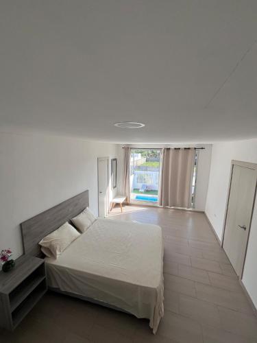 une chambre avec un lit et une grande fenêtre dans l'établissement Villa de Lujo con Piscina Privada y BBQ, Cerca al Mar - Casa Abigail, à Juan de Acosta