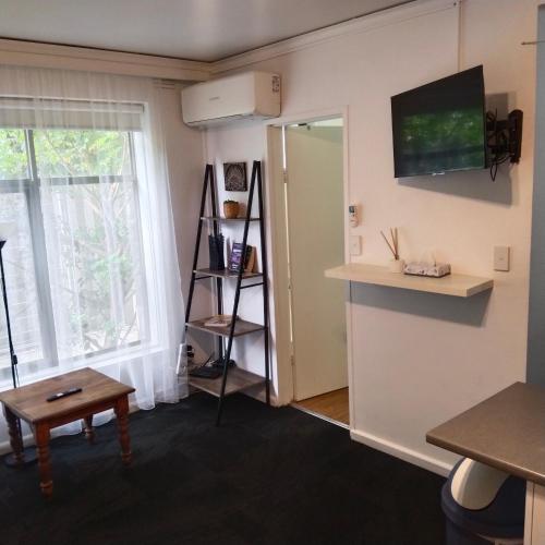 a room with a window and a table and a shelf at ShelleyStayz on Grey St in Melbourne