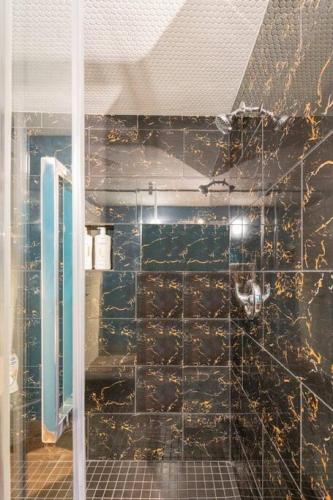a bathroom with a black tiled wall and a shower at Rustic Cozy Cabin with hot tub in Bragg Creek