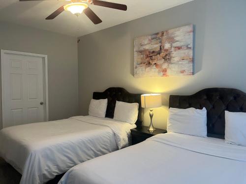 a bedroom with two beds and a ceiling fan at Resort Style Apt/Home in Houston Medical Centre in Houston