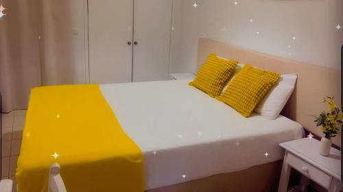 a white bed with two yellow pillows on it at Cantinho das Oliveiras in Geres
