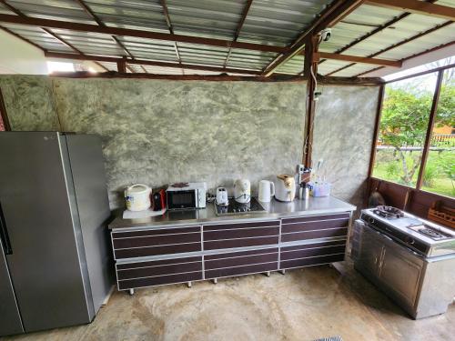 a small kitchen with a counter and a refrigerator at Hindad Nature Resort in Ban Ni Khu Hu