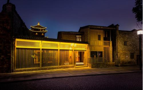 a building with a gate and a building with a tower at Jingdezhen Taoyi Shangnong Hotel in Jingdezhen