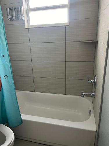 a bathroom with a tub and a toilet and a window at Chic & Cozy 1-bedroom Apartment with Free Parking in Houston