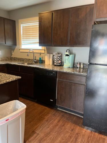 a kitchen with wooden cabinets and a stainless steel refrigerator at Chic & Cozy 1-bedroom Apartment with Free Parking in Houston