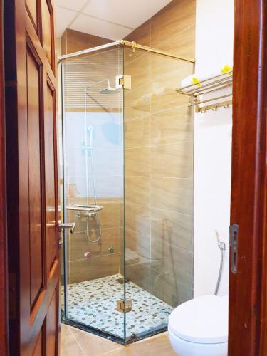 a glass shower in a bathroom with a toilet at Hoang Son Hotel - Can Tho in Can Tho