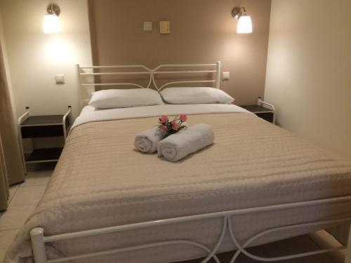 a bed with two towels with flowers on it at Sunny Studios in Svoronata