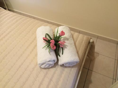 a pair of towels on a bed with flowers on them at Sunny Studios in Svoronata